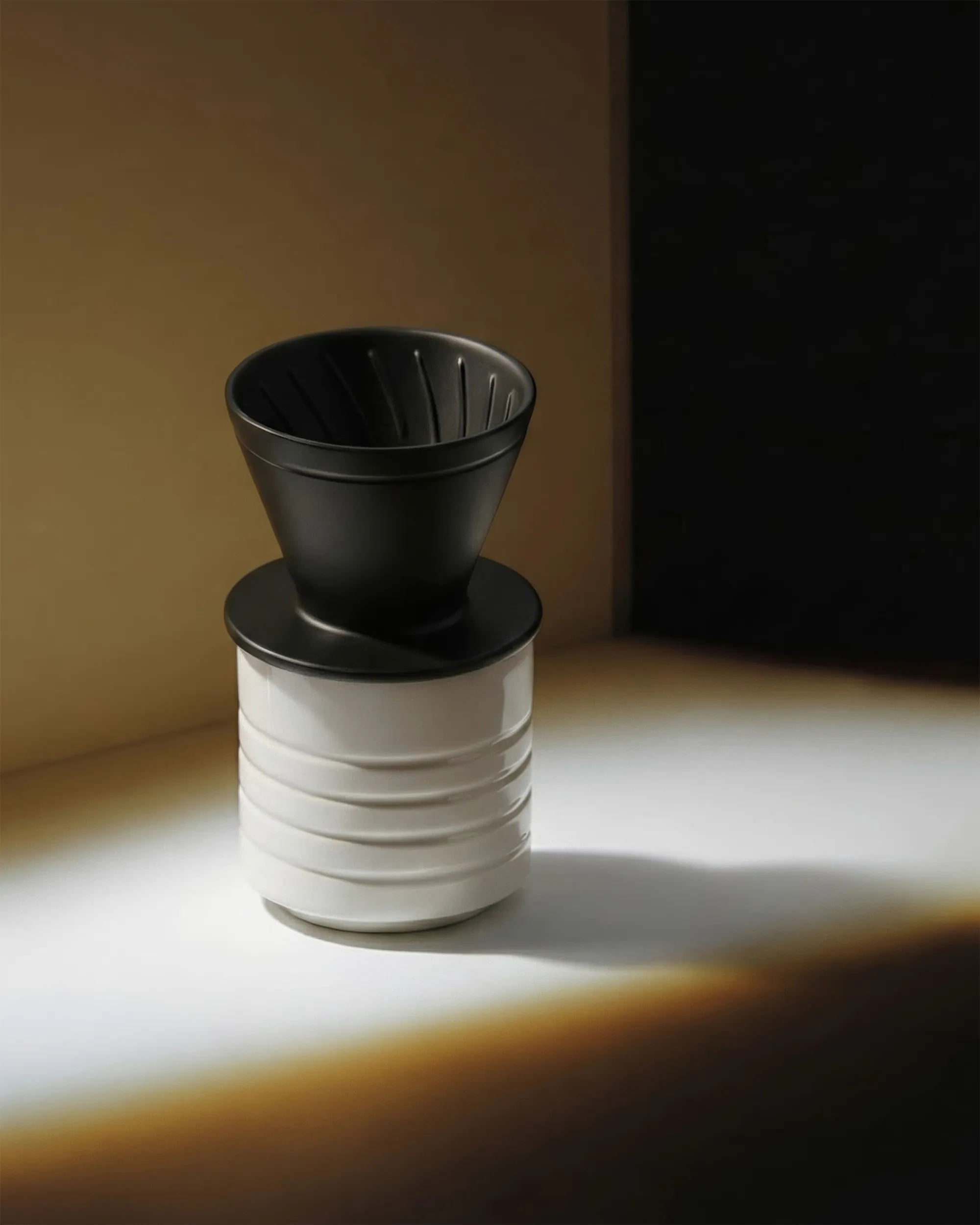 Керамический кофейный дриппер чёрно-белого цвета на белой поверхности, отбрасывающий тень.