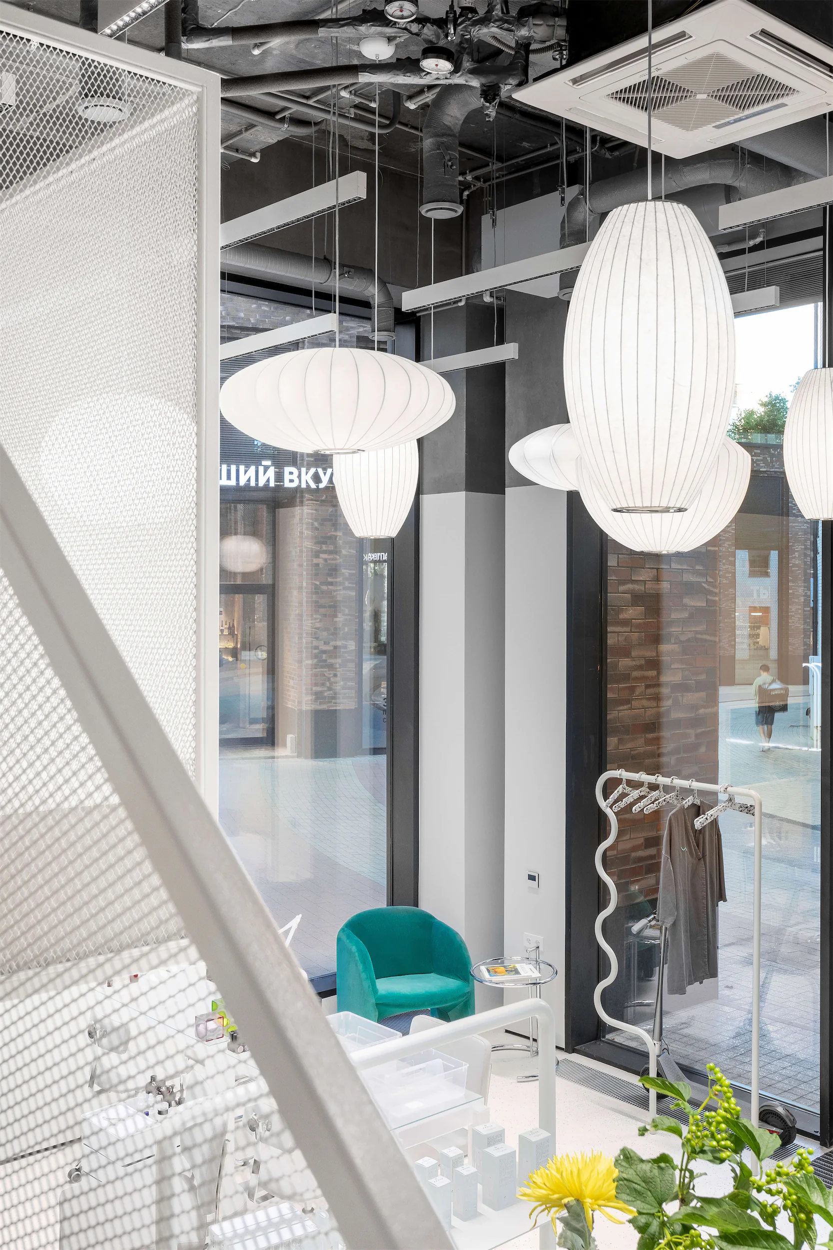 Современное пространство с белым креслом и подвесным светильником.