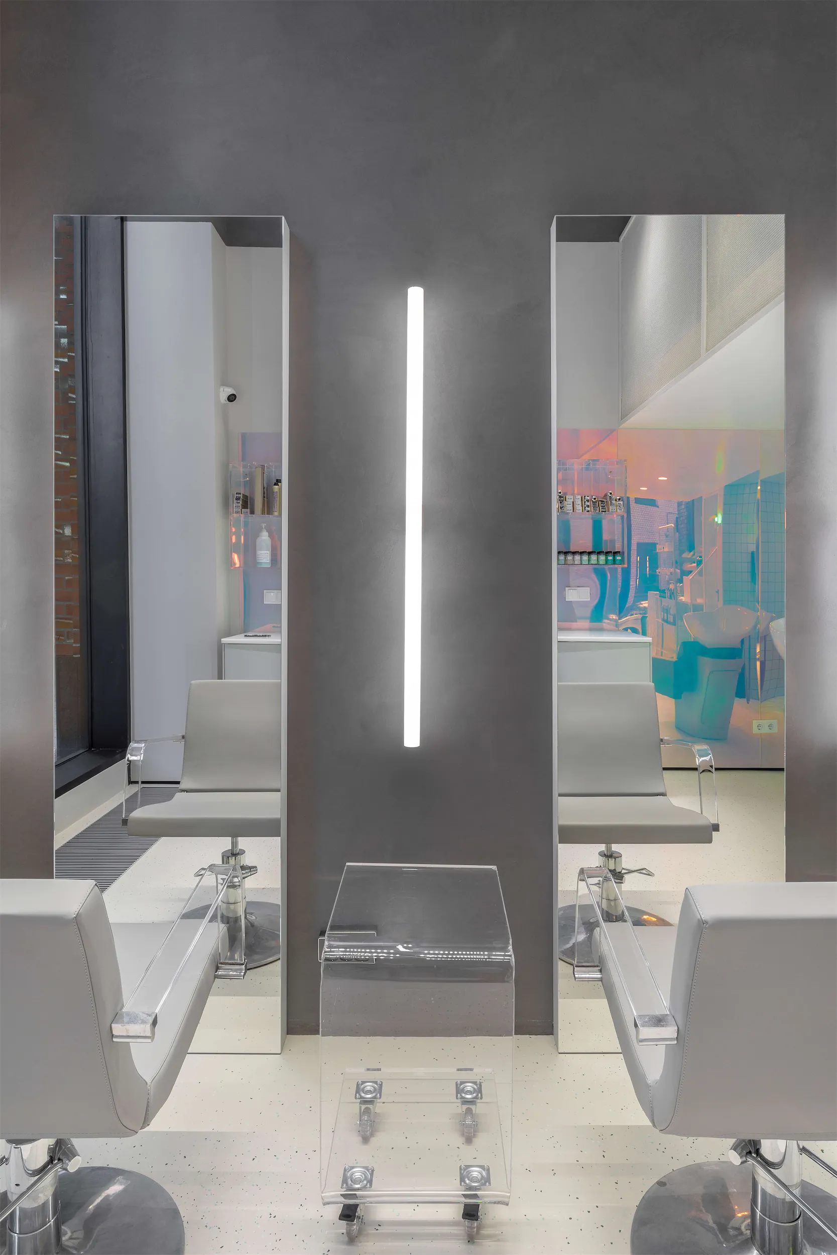 Современный интерьер салона с рядом кресел и зеркальной стеной.