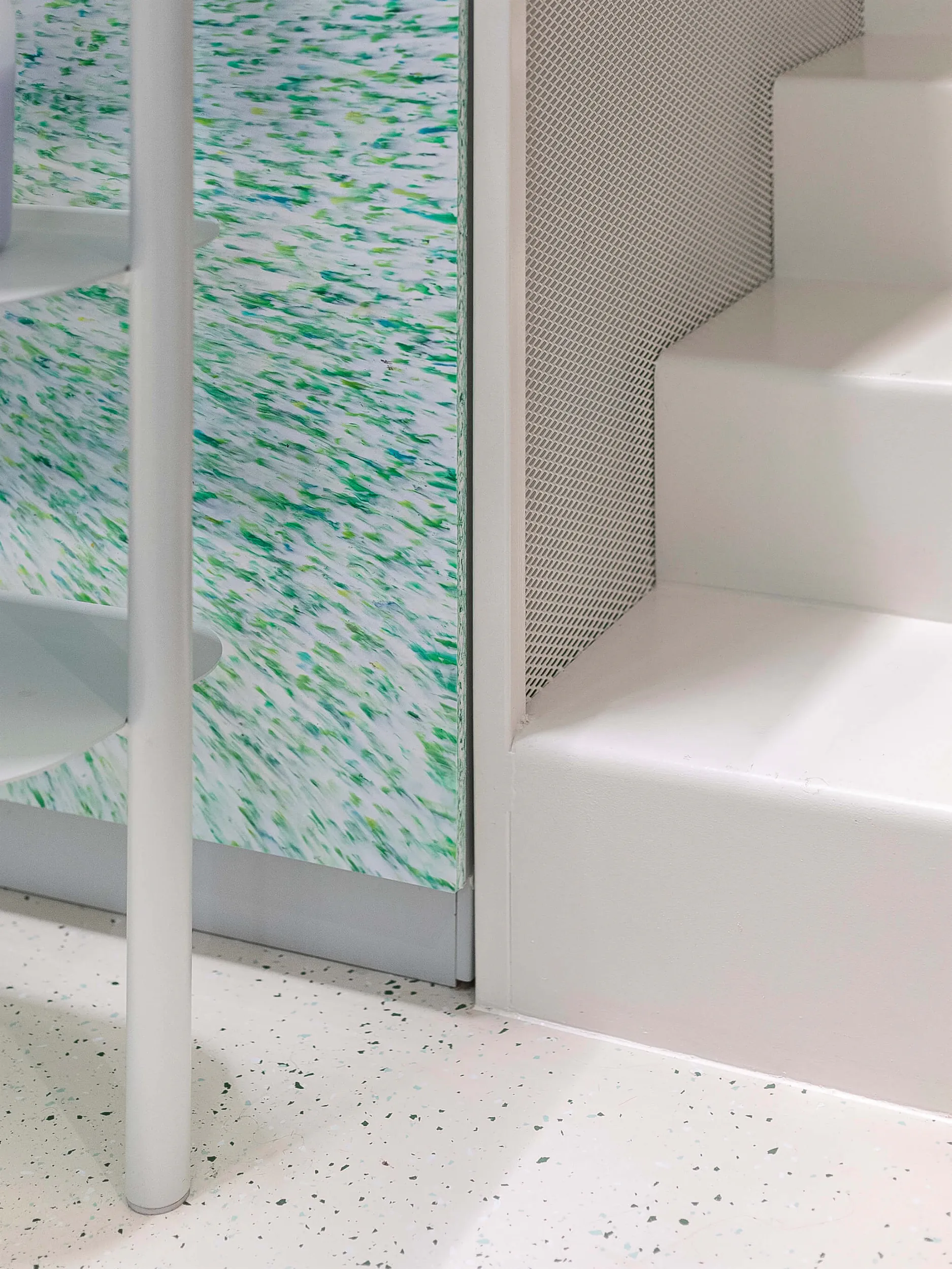 Белая лестница на фоне стены с зелено-белым узором.