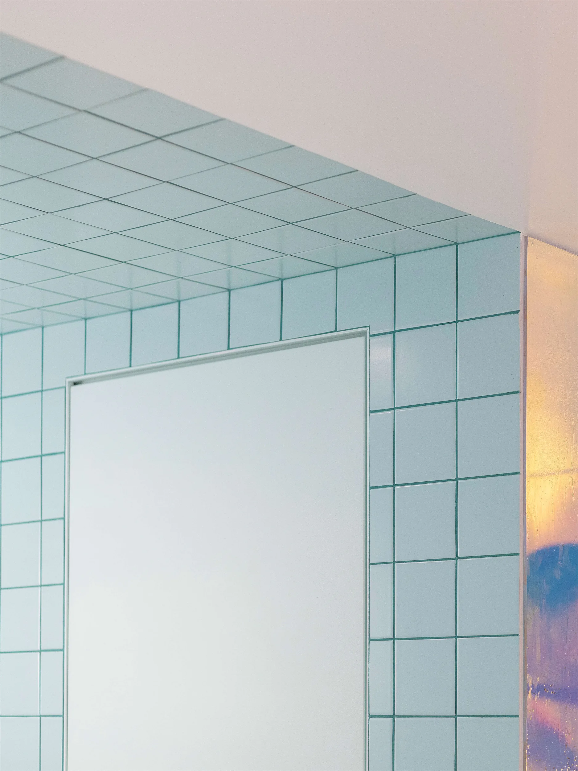 Стена с голубой плиткой, белая дверь и белый угол.