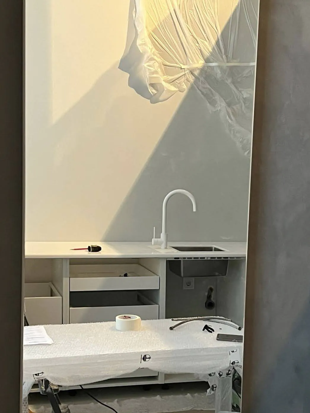 Белый процедурный стол, на заднем плане раковина и шкаф.