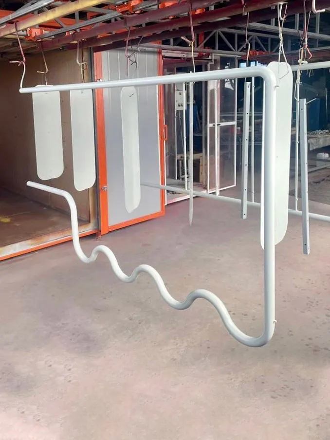 Белая металлическая рама с волнистым нижним краем, подвешенная к потолку.