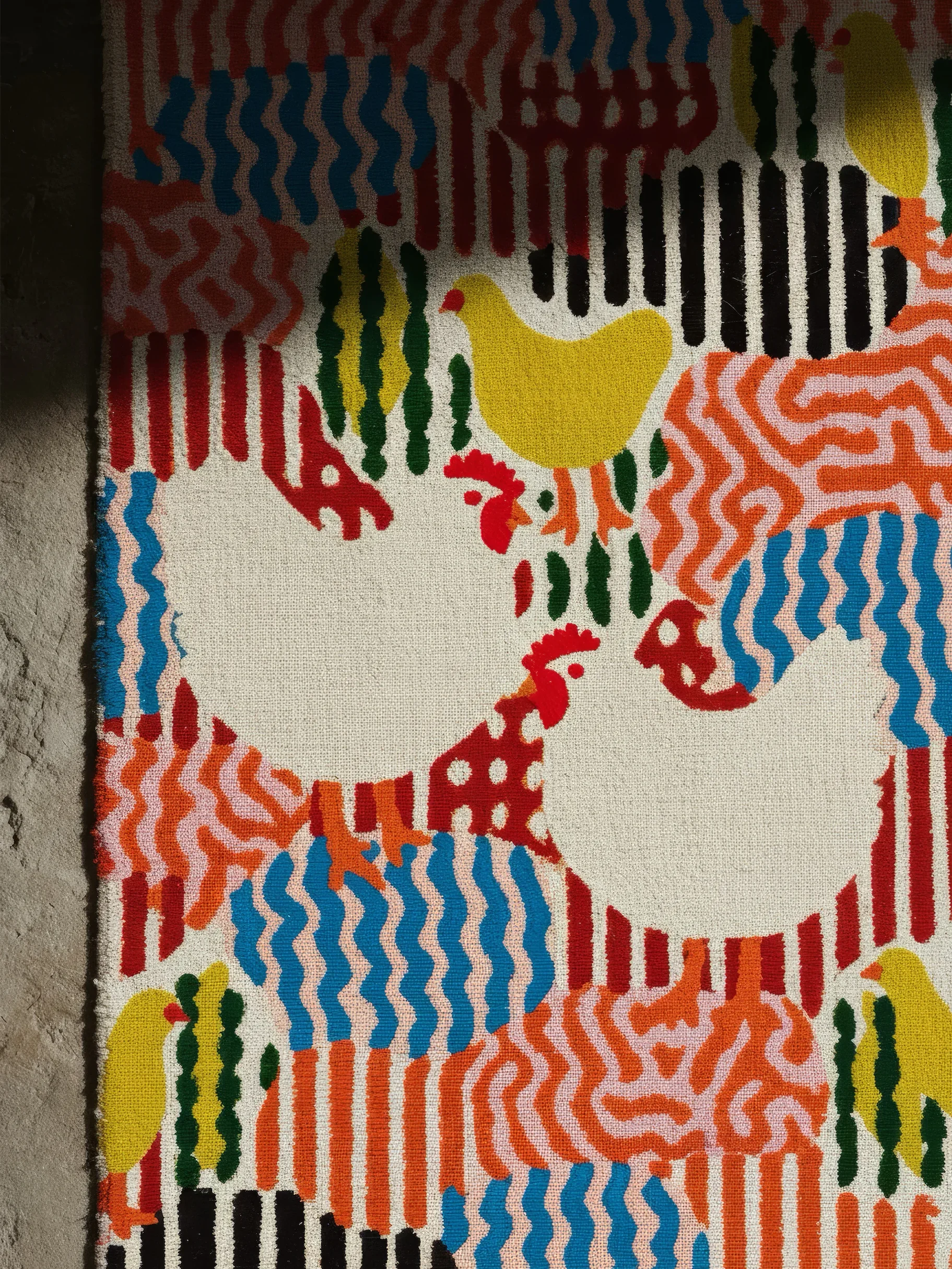 Яркая ткань с повторяющимся рисунком из кур и волнистых линий разных цветов.