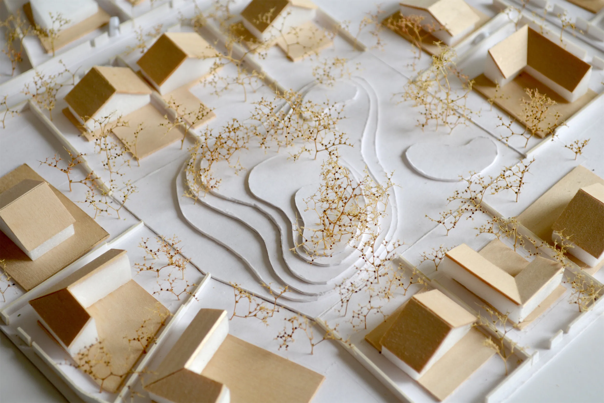 Белая архитектурная модель с золотыми акцентами и волнистой поверхностью.