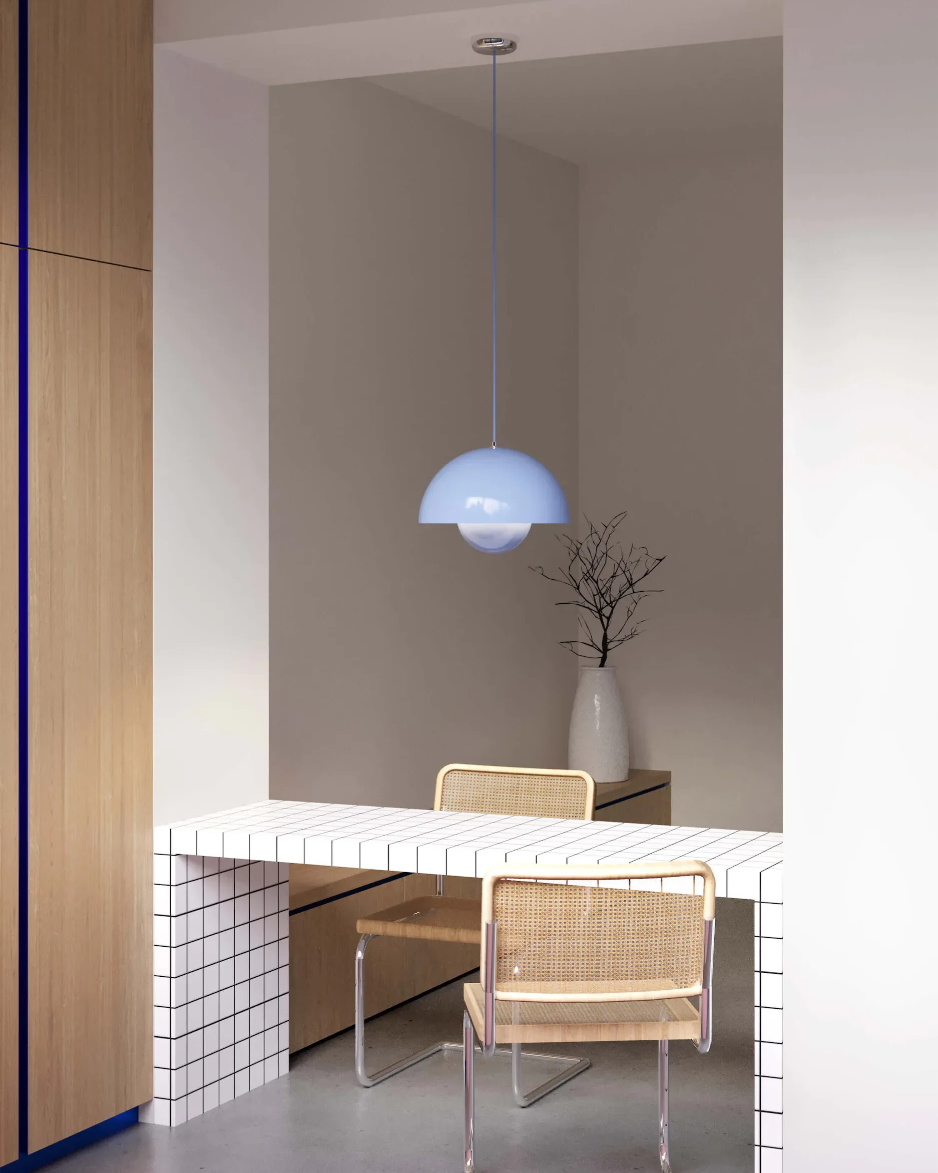 A minimalist dining room with a white table, wicker chair, and hanging light.