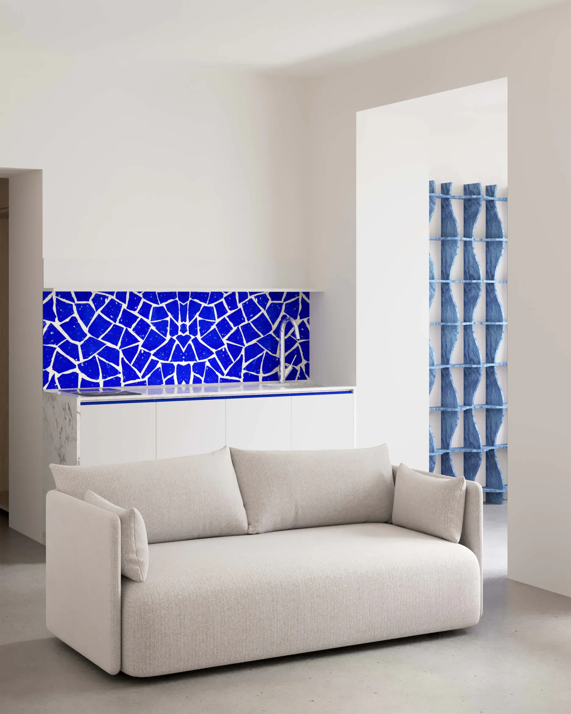 Белый диван перед стеной с синей мозаикой и синей узорчатой занавеской.
