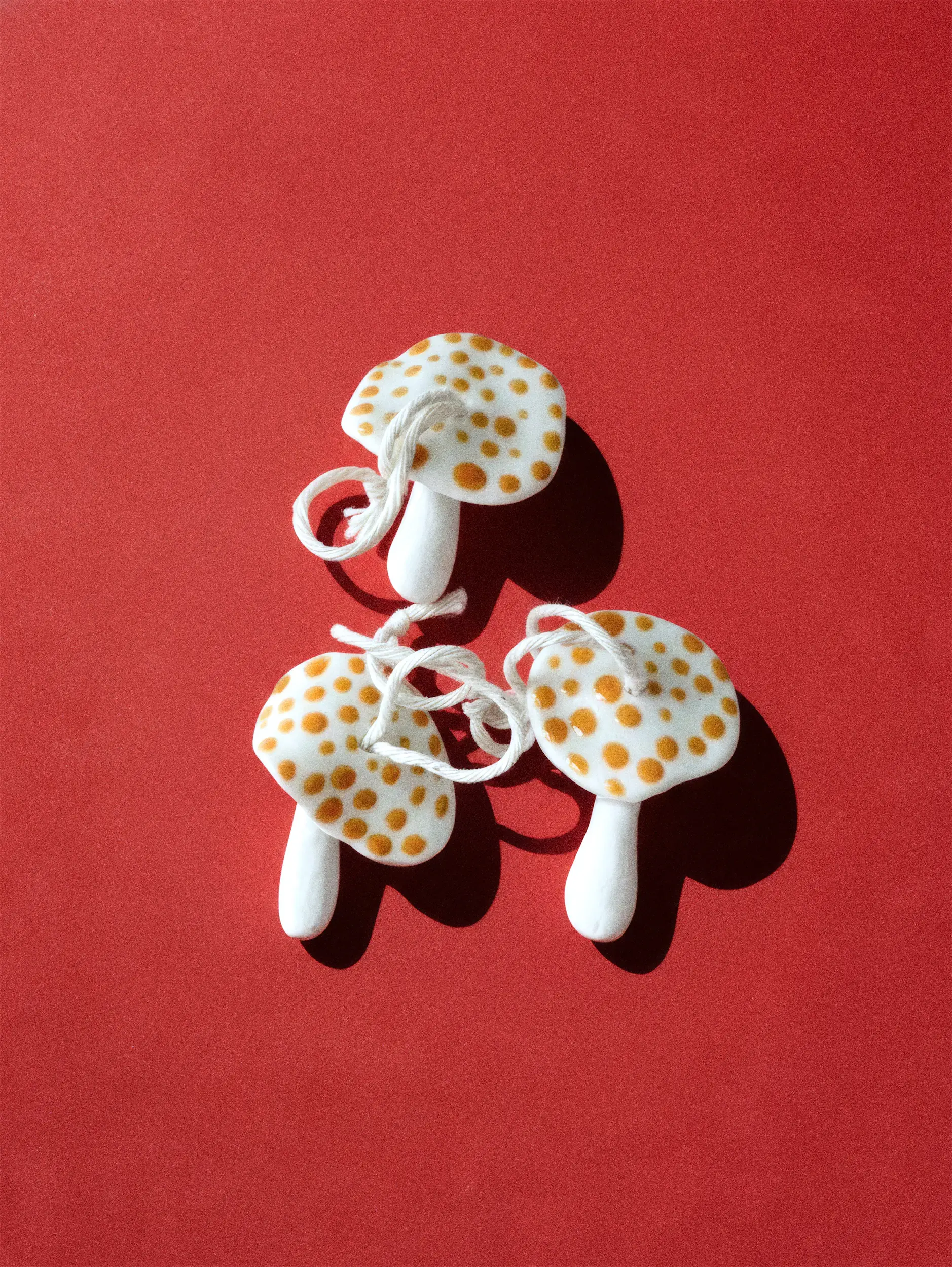 Белые грибы с жёлтыми пятнами на красном фоне.