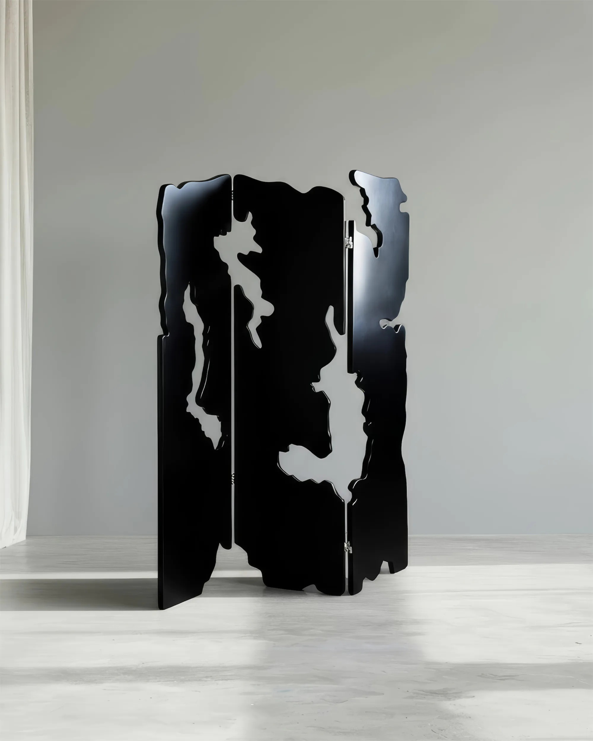 Чёрная металлическая ширма с фигурным вырезом у белой стены.
