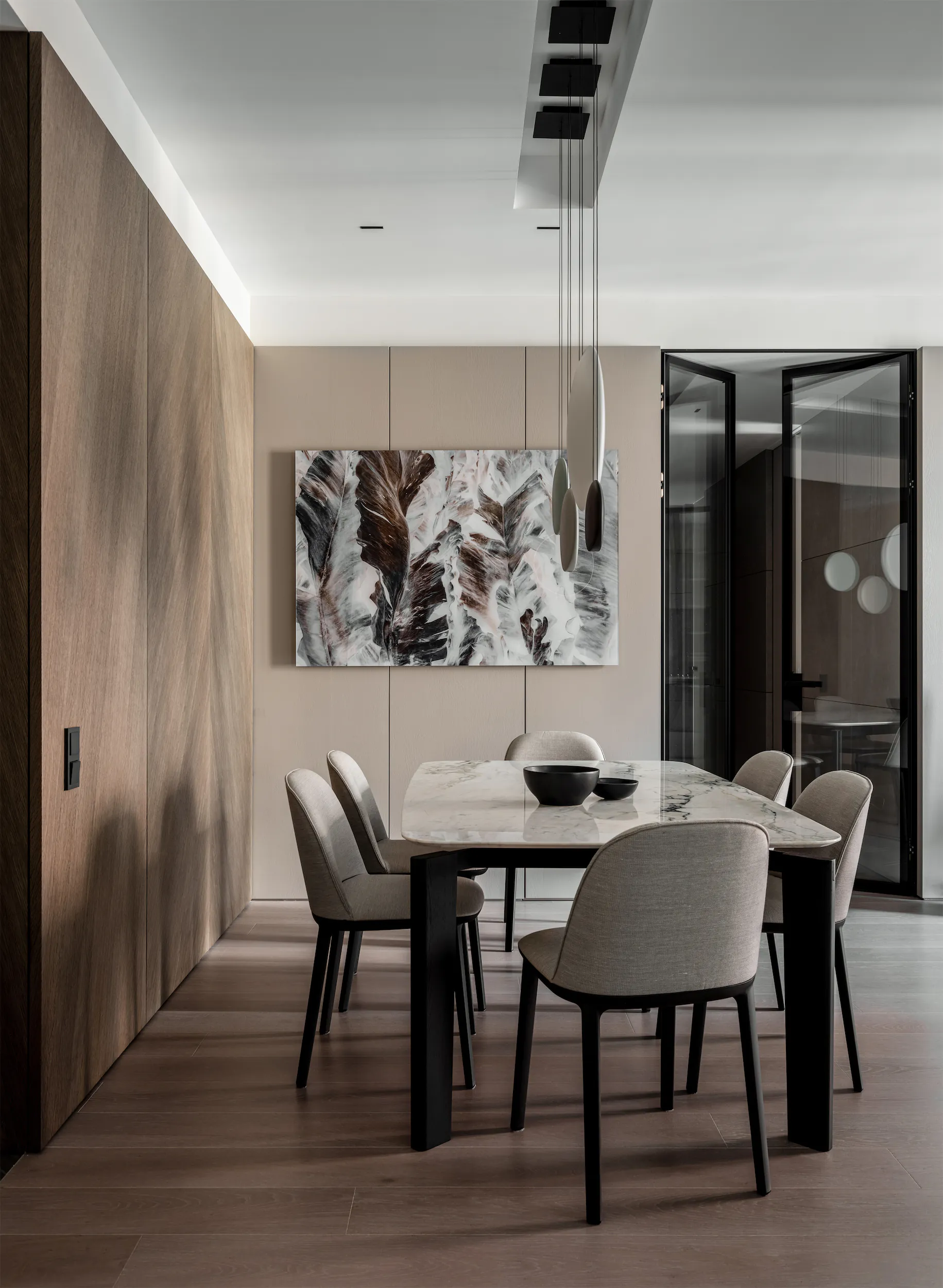 Столовая со столом, стульями и большой картиной на стене.